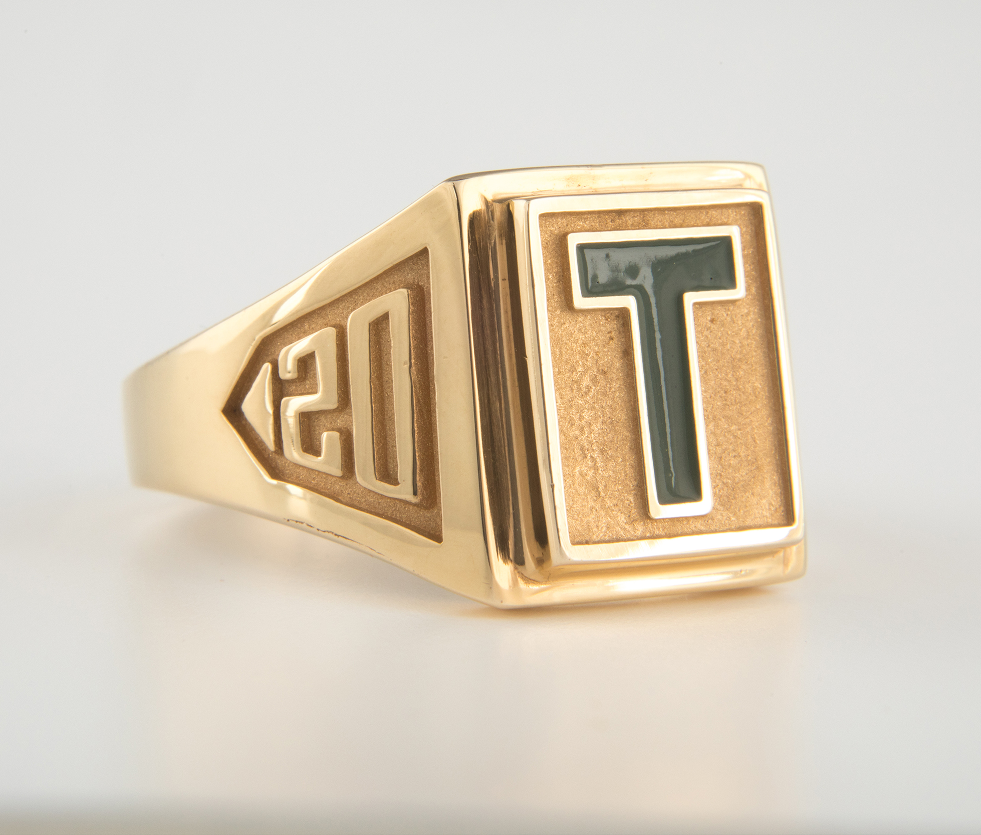 A gold St. Thomas University T-Ring